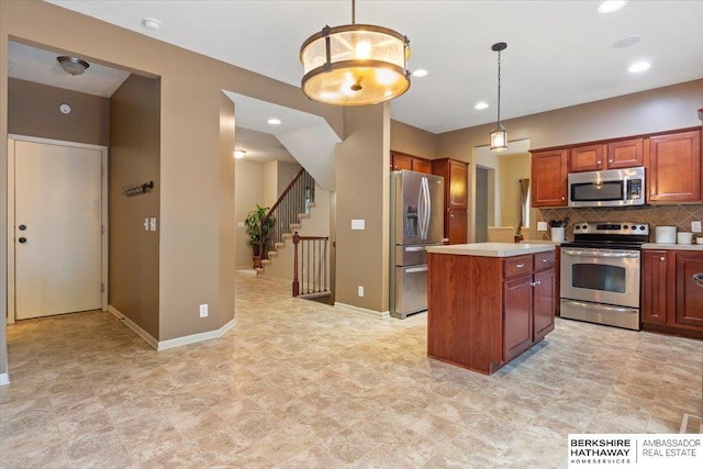 kitchen featuring appliances with stainless steel finishes, light countertops, a kitchen island, backsplash, and decorative light fixtures