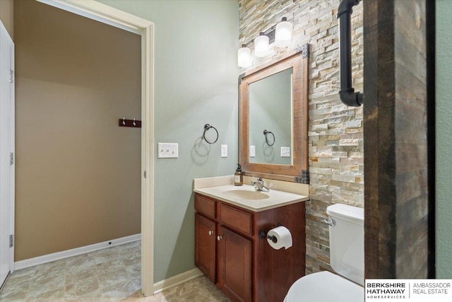 bathroom featuring vanity, toilet, and baseboards