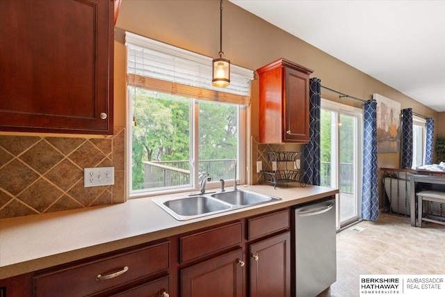 kitchen featuring dishwasher, a sink, backsplash, and decorative light fixtures
