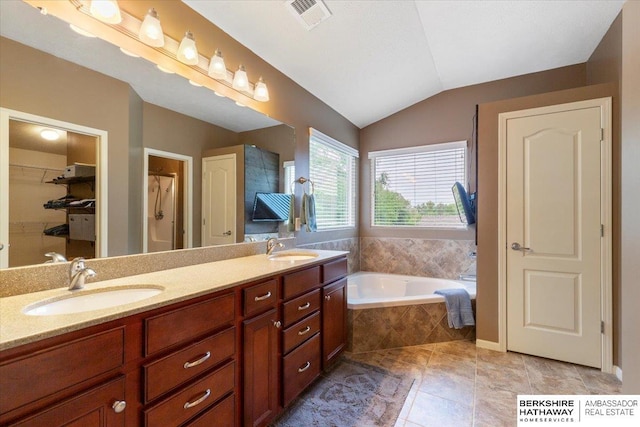 full bath with a garden tub, double vanity, tile patterned flooring, lofted ceiling, and a walk in closet