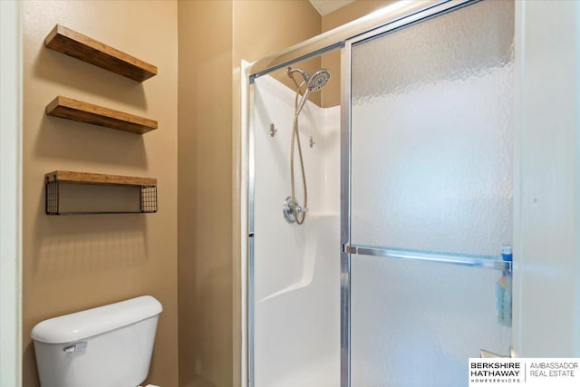 bathroom featuring a stall shower and toilet