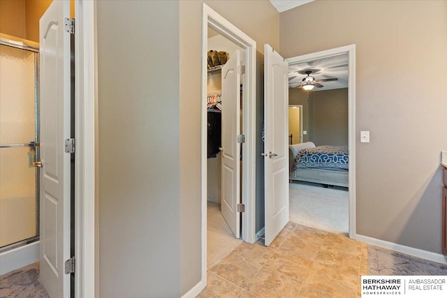 hall with baseboards and light colored carpet