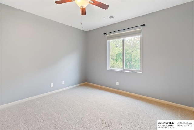 empty room with baseboards, a ceiling fan, and light colored carpet