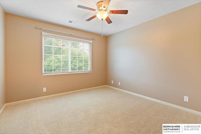 carpeted spare room featuring a ceiling fan and baseboards