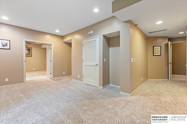 spare room with light carpet, recessed lighting, and baseboards
