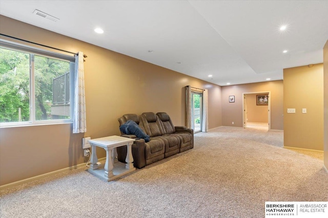 living area featuring light carpet, plenty of natural light, recessed lighting, and baseboards
