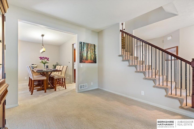 dining area featuring carpet floors, stairway, and baseboards