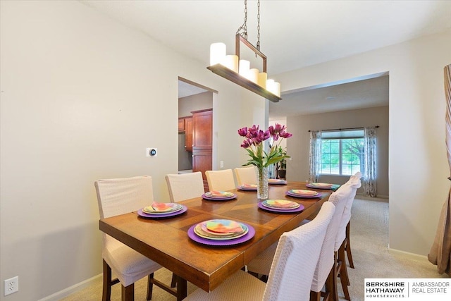 dining area featuring light colored carpet and baseboards