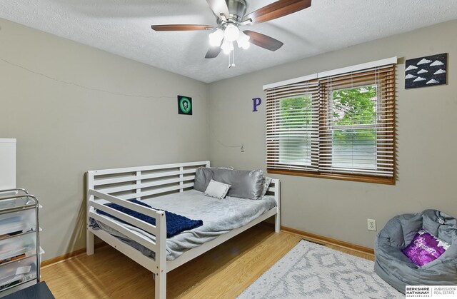 1611 N 150th Plz, Omaha, NE 68154 - bedroom with wood finished floors, a textured ceiling, baseboards, and ceiling fan
