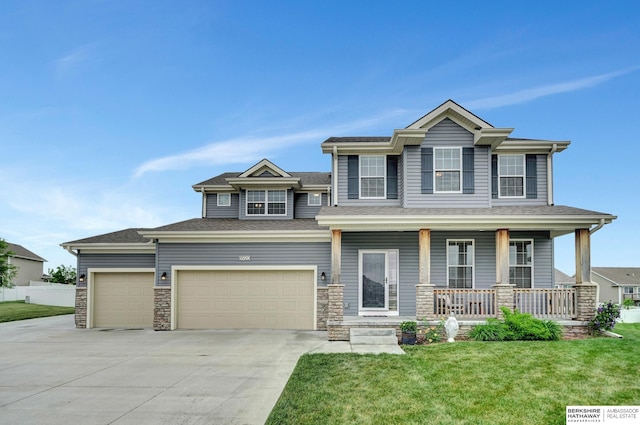 8920 Trader Ct, Lincoln, NE 68507 - view of front facade featuring covered porch, driveway, an attached garage, and stone siding