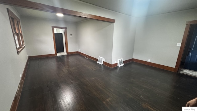 spare room featuring wood finished floors and baseboards