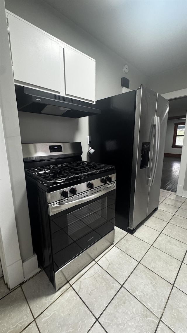 kitchen with stainless steel appliances, under cabinet range hood, white cabinetry, and light tile patterned flooring