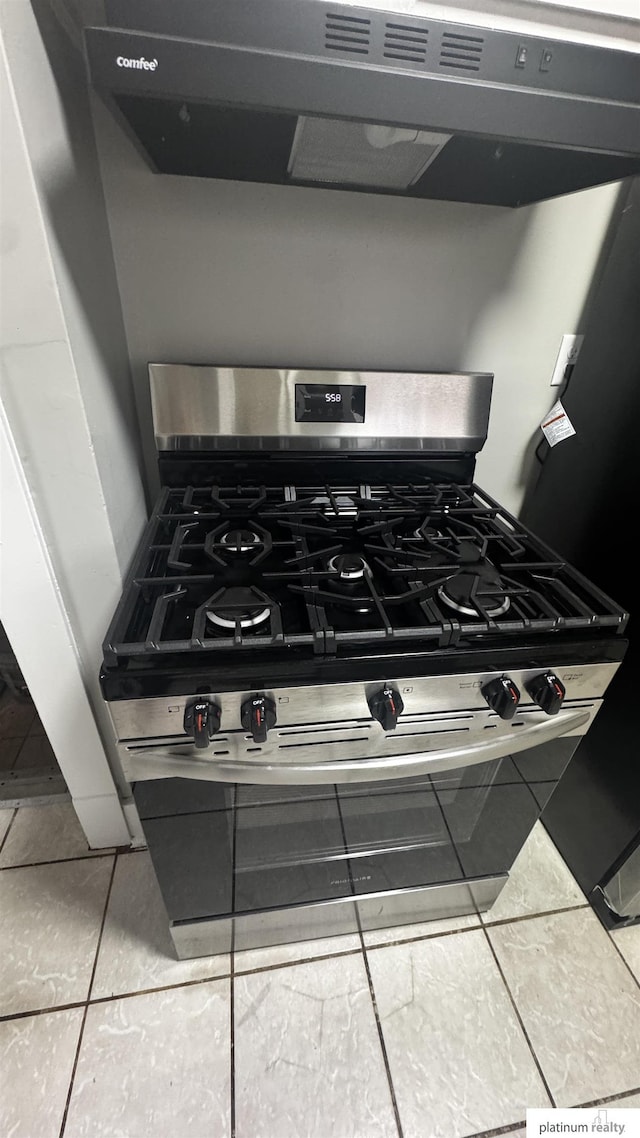 kitchen view of exhaust hood and stainless steel gas range oven