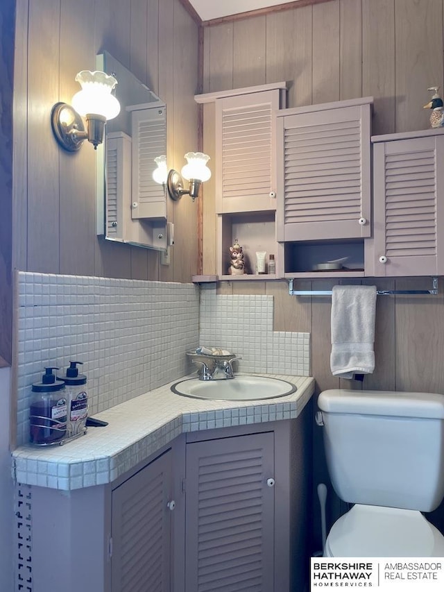 1200 H St, Pawnee City, NE 68420 - bathroom featuring decorative backsplash, toilet, and vanity