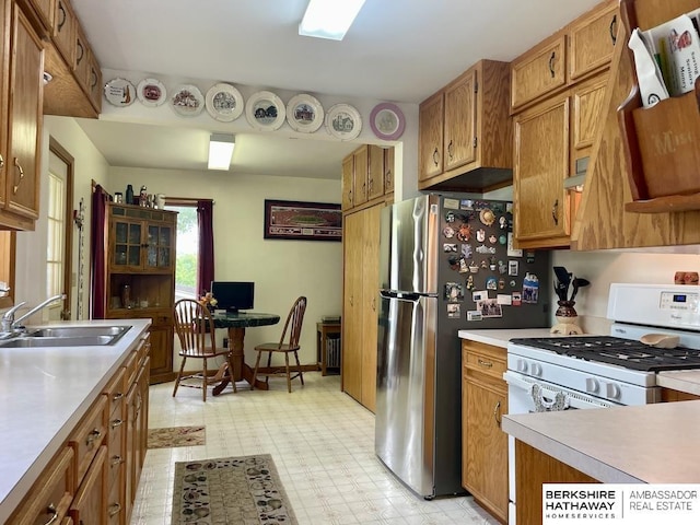 1200 H St, Pawnee City, NE 68420 - kitchen with a sink, brown cabinets, light countertops, light floors, and white gas stove