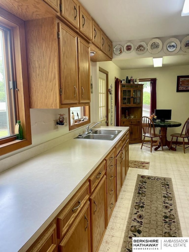 1200 H St, Pawnee City, NE 68420 - kitchen featuring a sink, light flooring, light countertops, and brown cabinets