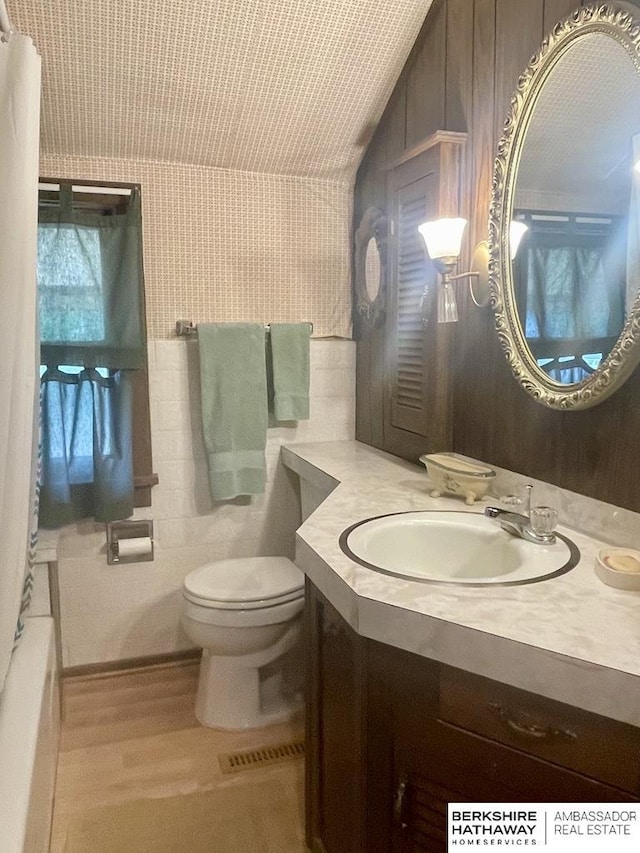 1200 H St, Pawnee City, NE 68420 - full bath featuring toilet, vanity, wood finished floors, a tub, and lofted ceiling