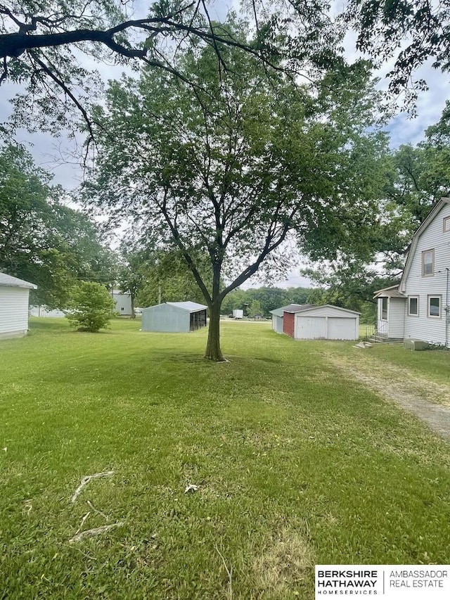 1200 H St, Pawnee City, NE 68420 - view of grassy yard with a detached garage and an outdoor structure