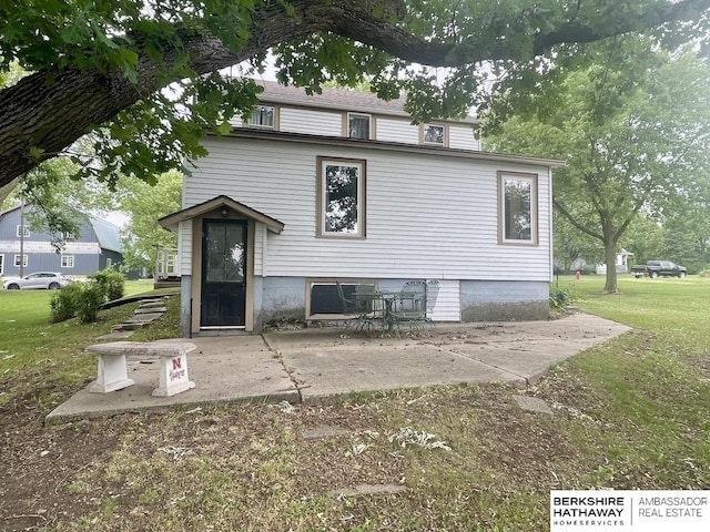 1200 H St, Pawnee City, NE 68420 - rear view of house featuring a patio and a lawn