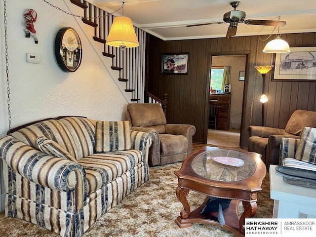 1200 H St, Pawnee City, NE 68420 - living area featuring stairway, wooden walls, a ceiling fan, and ornamental molding