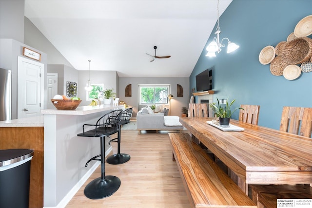 dining space featuring vaulted ceiling, light wood-style flooring, and a chandelier