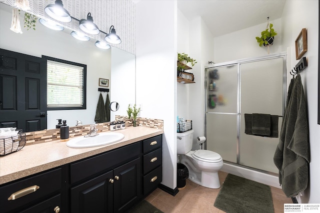 full bath featuring tile patterned floors, toilet, vanity, and a shower stall