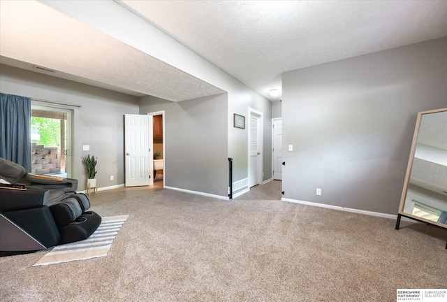 living room with carpet flooring, baseboards, and a textured ceiling