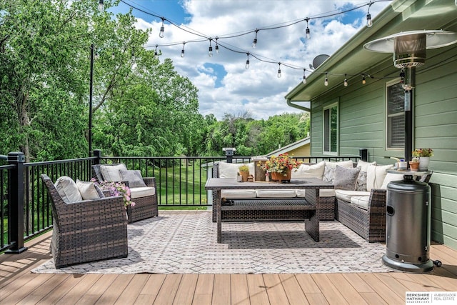 wooden terrace with an outdoor living space