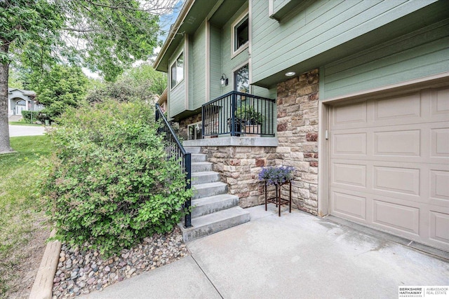 view of exterior entry with stone siding and a garage