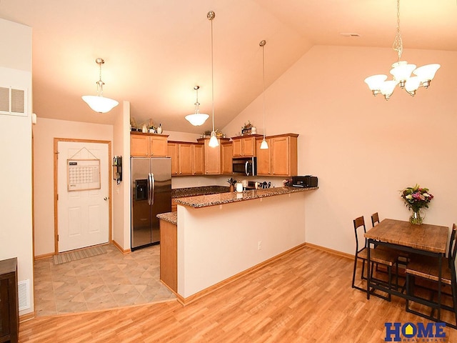 8946 Broken Spoke Dr, Lincoln, NE 68507 - kitchen with stainless steel appliances, a peninsula, a chandelier, stone countertops, and decorative light fixtures