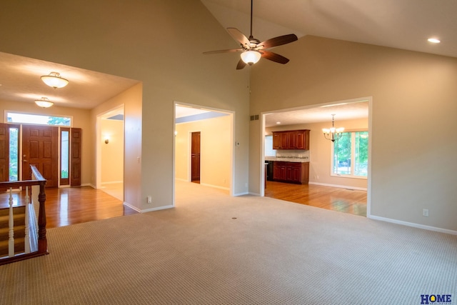 9160 Pioneer Ct, Lincoln, NE 68520 - unfurnished living room with light colored carpet, baseboards, a chandelier, and high vaulted ceiling