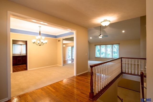 9160 Pioneer Ct, Lincoln, NE 68520 - hall with a chandelier, an upstairs landing, wood finished floors, baseboards, and carpet floors