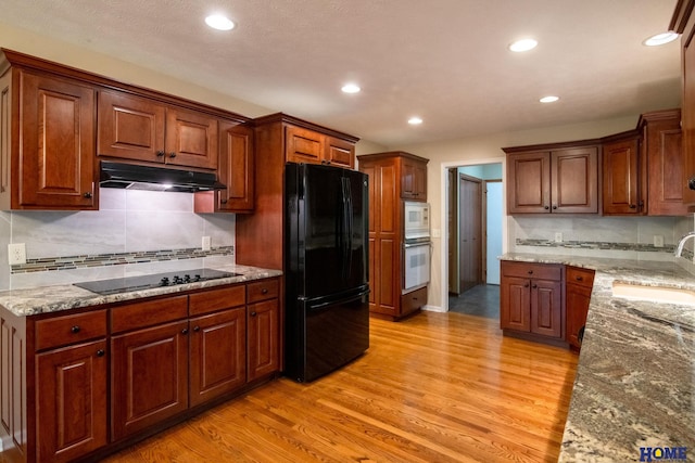 9160 Pioneer Ct, Lincoln, NE 68520 - kitchen featuring black appliances, under cabinet range hood, light wood-style floors, a sink, and recessed lighting