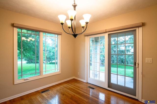 9160 Pioneer Ct, Lincoln, NE 68520 - empty room featuring a chandelier, plenty of natural light, and wood finished floors