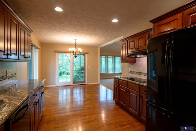 9160 Pioneer Ct, Lincoln, NE 68520 - kitchen with black appliances, under cabinet range hood, baseboards, a chandelier, and recessed lighting