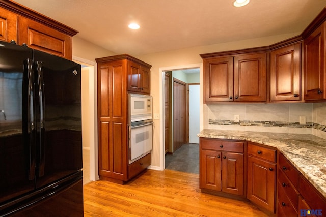 9160 Pioneer Ct, Lincoln, NE 68520 - kitchen featuring white appliances, light wood-style flooring, light stone countertops, decorative backsplash, and recessed lighting