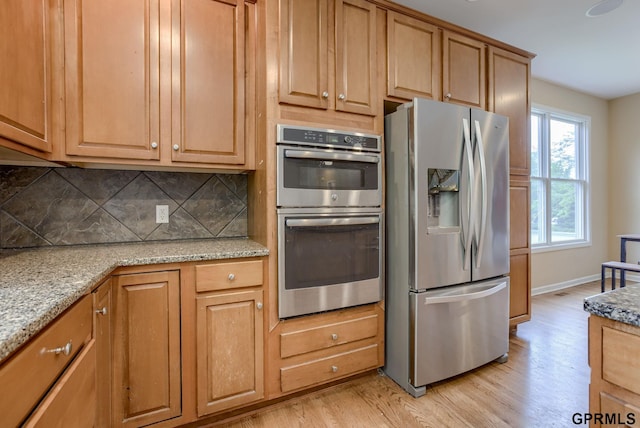 6732 S 169th Ave, Omaha, NE 68135 - kitchen with appliances with stainless steel finishes, light wood-style flooring, tasteful backsplash, and light stone countertops