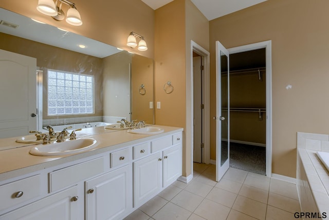 6732 S 169th Ave, Omaha, NE 68135 - bathroom with a garden tub, tile patterned floors, double vanity, a walk in closet, and baseboards