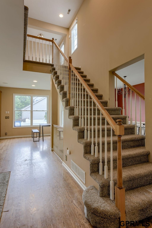 6732 S 169th Ave, Omaha, NE 68135 - stairway with wood finished floors, a high ceiling, and baseboards