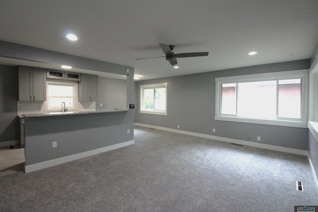 1425 Meadow Dale Dr, Lincoln, NE 68505 - unfurnished living room featuring ceiling fan, a sink, healthy amount of natural light, light carpet, and recessed lighting