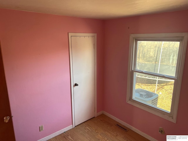 unfurnished room with light wood finished floors and baseboards