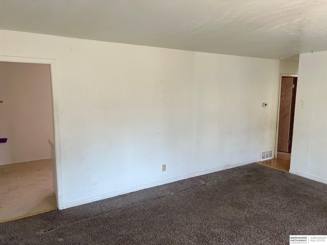spare room featuring carpet floors and baseboards