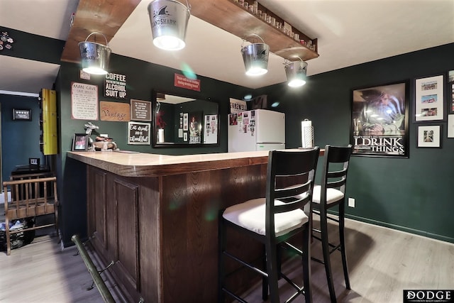 1131 Elizabeth Cir, Fremont, NE 68025 - indoor dry bar with freestanding refrigerator and wood finished floors