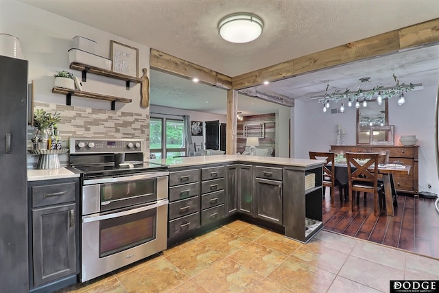 1131 Elizabeth Cir, Fremont, NE 68025 - kitchen with range with two ovens, a peninsula, open shelves, beam ceiling, and light countertops