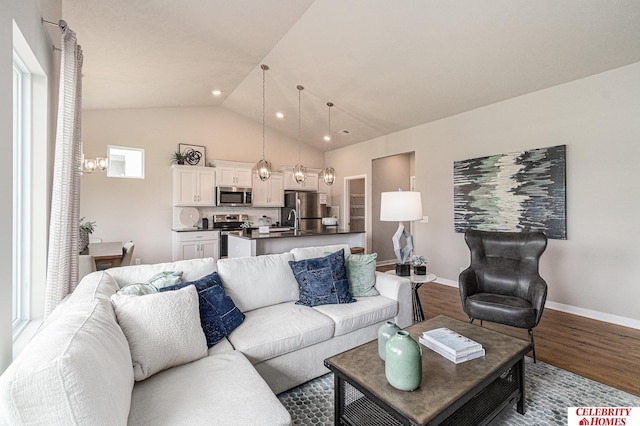 6413 N 168th Ave, Omaha, NE 68116 - living room featuring wood finished floors, a chandelier, baseboards, lofted ceiling, and recessed lighting