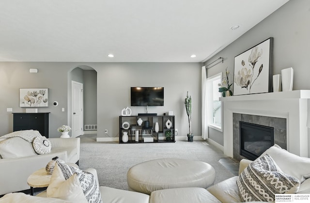7211 S 174th St, Omaha, NE 68136 - living room featuring carpet, arched walkways, a tiled fireplace, baseboards, and recessed lighting