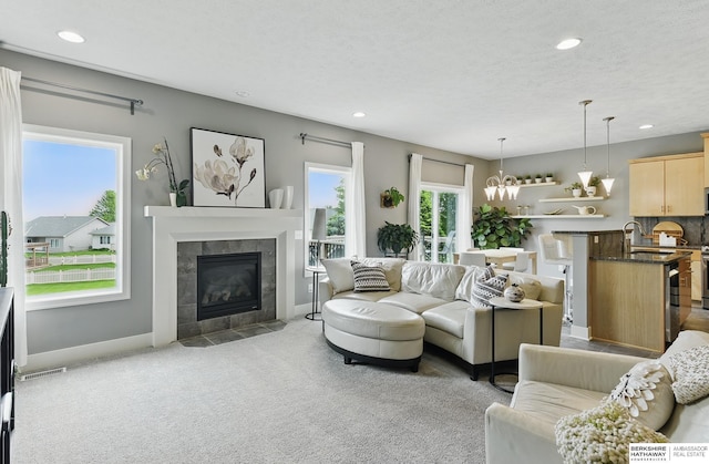7211 S 174th St, Omaha, NE 68136 - carpeted living area with a tile fireplace, a sink, recessed lighting, and baseboards