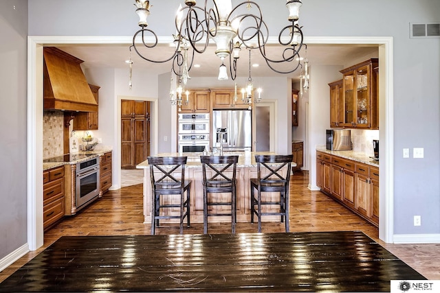 3400 Firethorn Ter, Lincoln, NE 68520 - kitchen with stainless steel appliances, a chandelier, premium range hood, a center island, and dark wood-type flooring