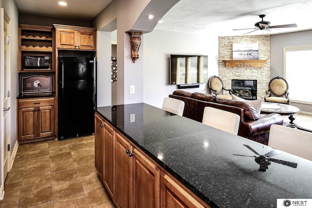 3400 Firethorn Ter, Lincoln, NE 68520 - kitchen featuring freestanding refrigerator, a ceiling fan, a stone fireplace, open floor plan, and recessed lighting