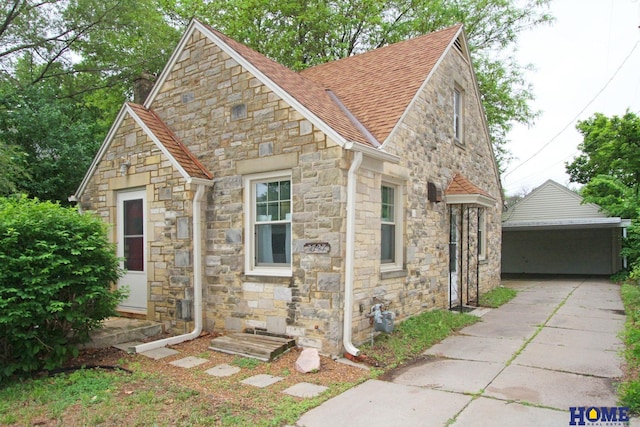 2727 S 19th St, Lincoln, NE 68502 - tudor house with stone siding, a shingled roof, and an outdoor structure